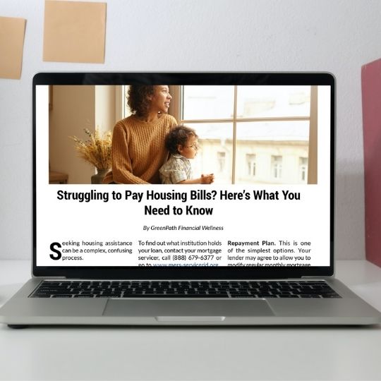 "Struggling to Pay Bills" article displayed on laptop